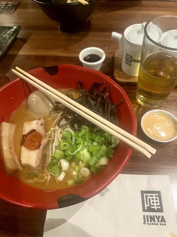 Red bowl with ramen, chopsticks, and fillings from Jinya Ramen in Victory Park, Dallas